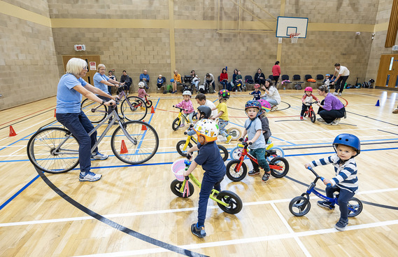 An instructor and group of children taking part in our balance bike club
