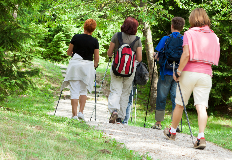 four women walking with poles through a park