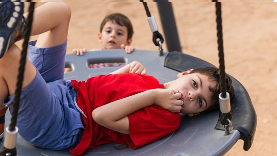 child lying on a basket swing