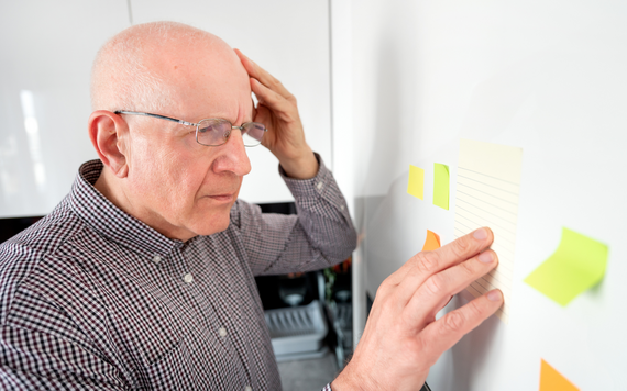 Dementia awareness week. Older man looking at sticky notes