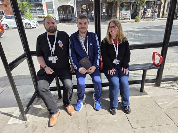 two young men and a young woman sitting in a bus shelter in Wokingham town centre