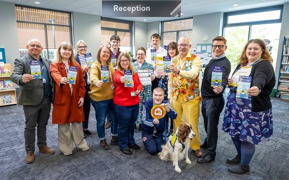 Launch of Safe Places in the library, with a group holding the flyers
