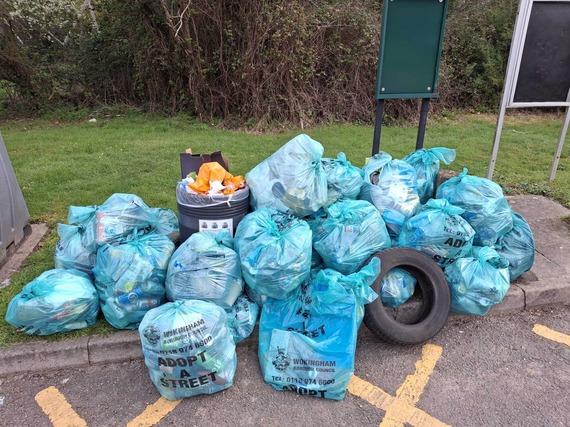 Dozens of green waste sacks collected together with a car tyre