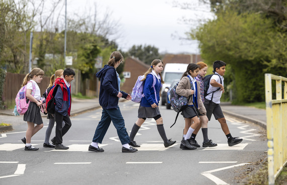 A group of school children crossing the road on a zebra crossing