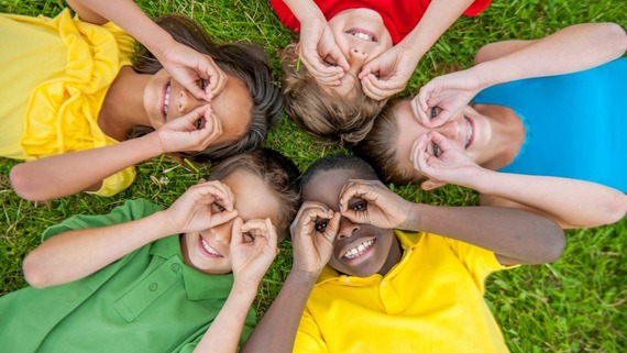 group of children lying on the ground looking up at the camera
