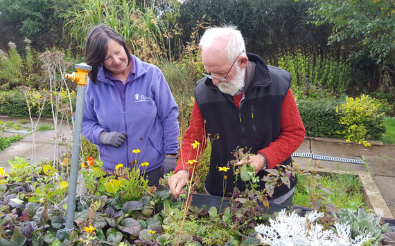 A volunteer from Thrive supporting an older man