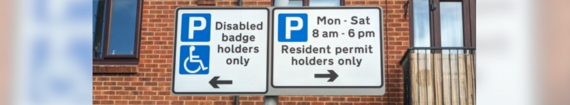 close up on signage in a residents parking permit zone including disabled spaces