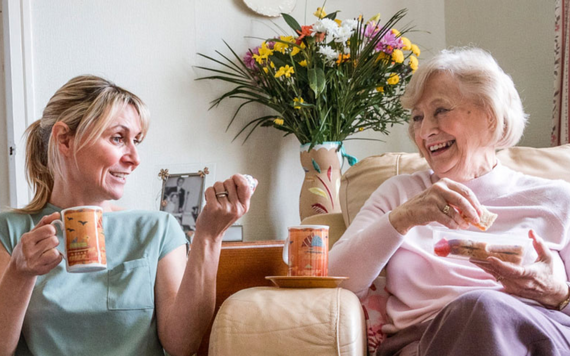 Elderly person speaking with a befriender over coffee