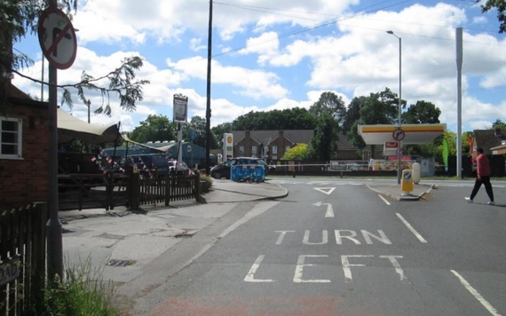 driver's eye view of a junction joining a major road with "turn left" markings in the lane