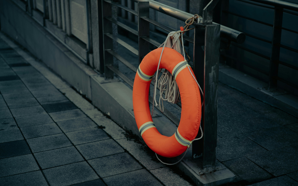 Orange life ring beside water, highlighting advice to stay safe around lakes and rivers.