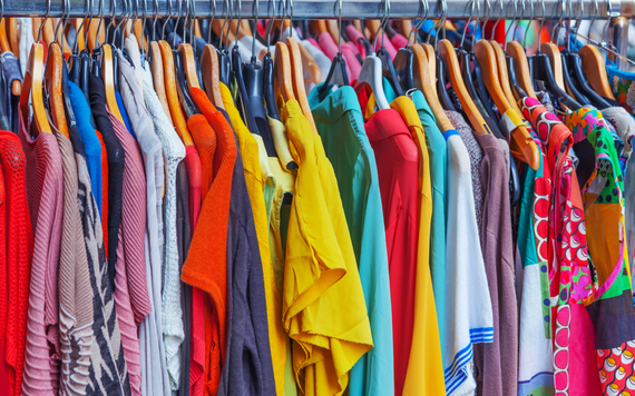 A brightly coloured range of clothing hung on a rack