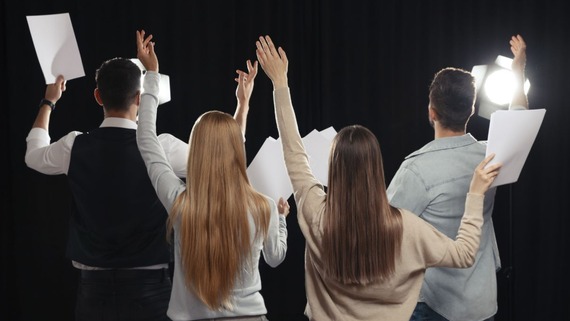 image of children holding scripts, rehearsing a play