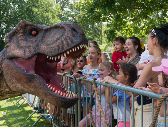 An image of families interacting with a life size T Rex