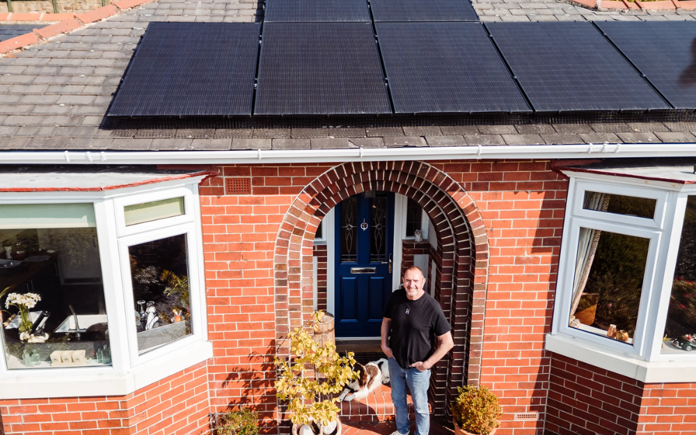 Drone footage of a home with solar on its roof and the homeowner in the doorway