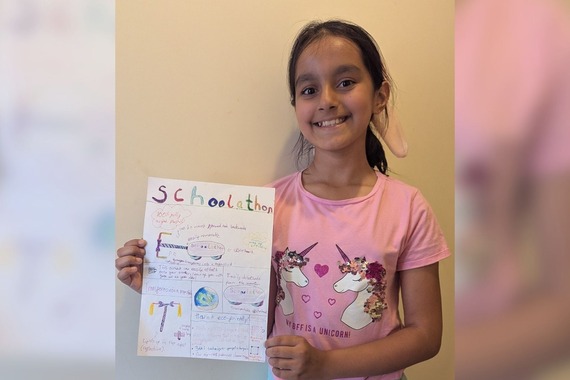 a young girl holds up a hand-drawn picture of a skateboard with a handle that becomes a hover board