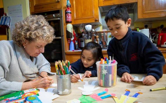 Home-Start. A woman with two children colouring