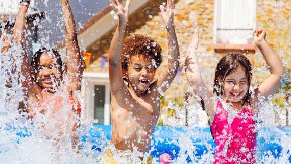 children splashing in a paddling pool
