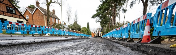 a road being resurfaced, with the old layer stripped off and waiting for new tarmac to be laid