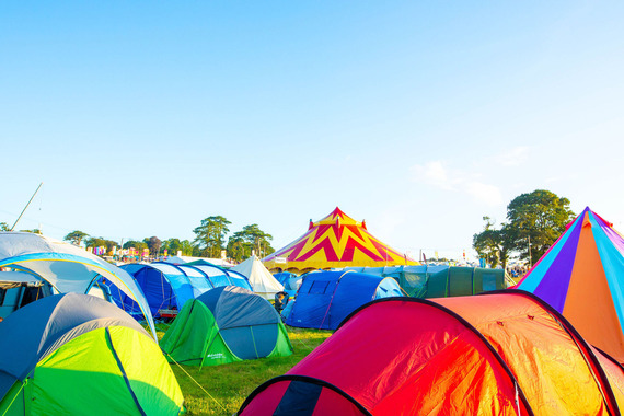 Festival campsite with colourful tents at an outdoor music festival.