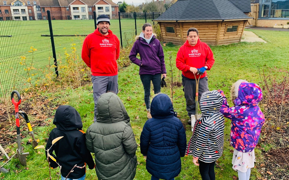 Freely Fruity volunteers teaching children how to plant a tree