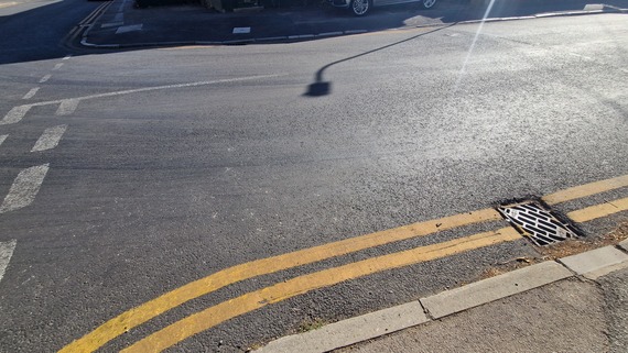 a road where the surface has become very smooth and flat as a result of wear from car tyres