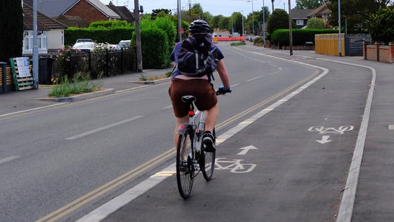 A cyclist rides along a cycle track in Woodley, marked with markings to show the track is two-way
