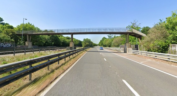 View of the footbridge over the A3290 at Earley station, as seen from a driver's point of view on the dual carriageway