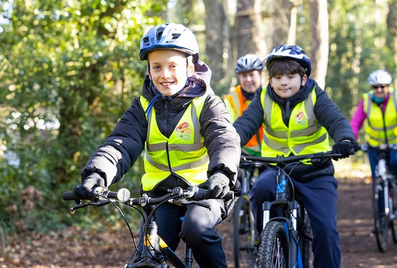 a child smiles at the camera while riding past on a country track