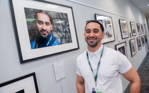 A man stood next to a framed photo of himself