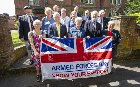 Council representatives and veterans holding the armed forces day flag