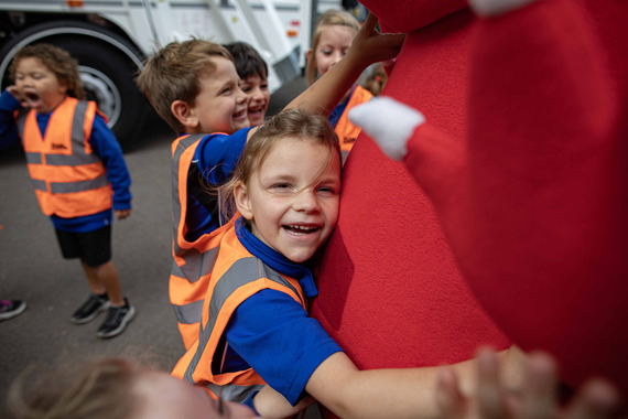 Pupil hugs Whitney the Wasteater during a Recycle Week visit to St Nicholas CE Primary School in Hurst.