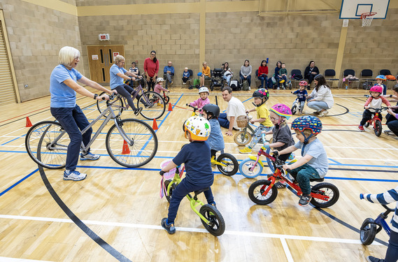 Instructor and group of young children taking part in Balance Bike Club