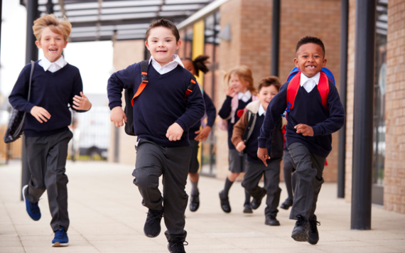 A group of children in school uniform running towards the camera 