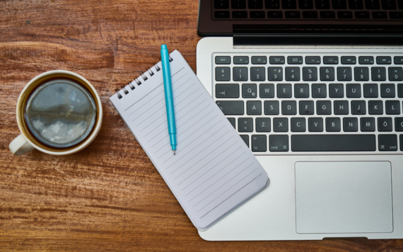 A coffee, laptop and notebook