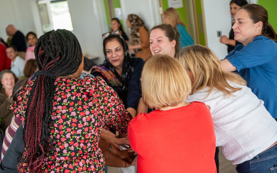 People at the Shinfield Together event stood in a circle with their hands together in the middle