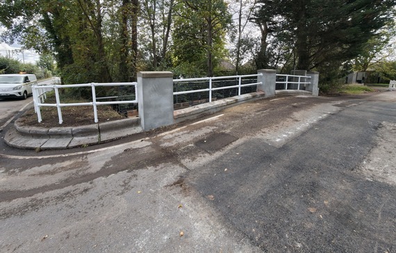 new railings and parapet on Swallowfield bridge after being repaired, with new surface patching on the road itself