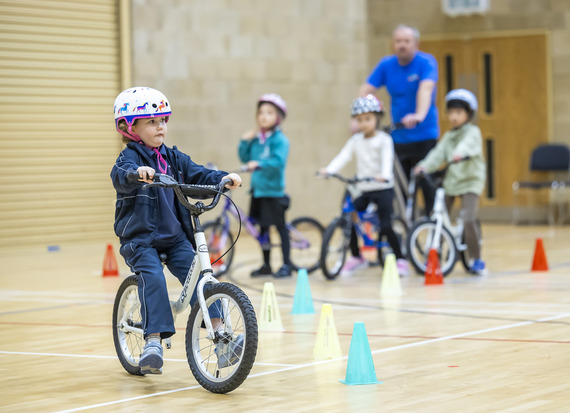 A group of children learn to ride a bike at Learn to Ride sessions