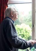 Older gentleman looking out of window