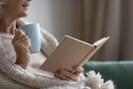 Lady with mug reading open book