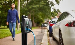 Electric vehicle chargepoint and man walking