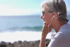 woman on beach with earbuds
