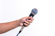 Hand holding out a microphone