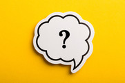 White speech bubble containing a black question mark against a yellow background