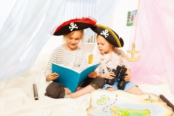 An image of two children in pirate costumes reading a book