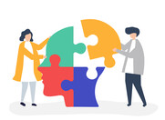 Brain made of multi-coloured puzzle pieces being assembled by two people