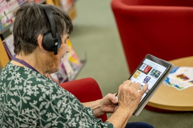 A customer looking at a tablet in a library