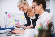 2 women looking at paper documents
