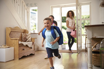 children running through a front door with an adult behind them