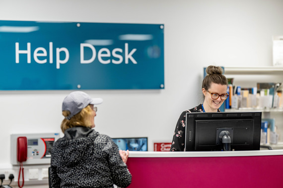 Library staff at help desk with customer