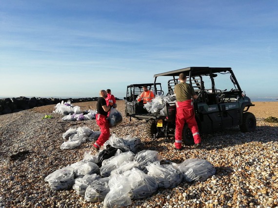 Workers clearing materials from beach